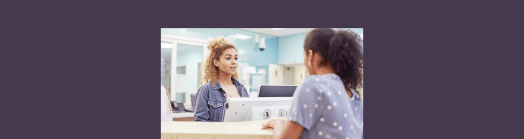 A patient talking to a person at a desk